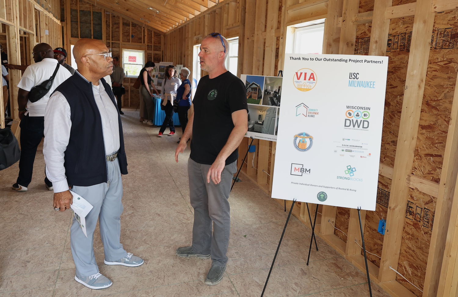 Grady Crosby walks through the basic wooden structure of a home under construction — affordable housing