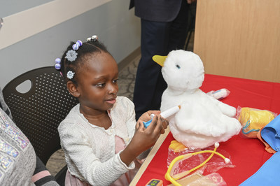 girl playing with aflac duck