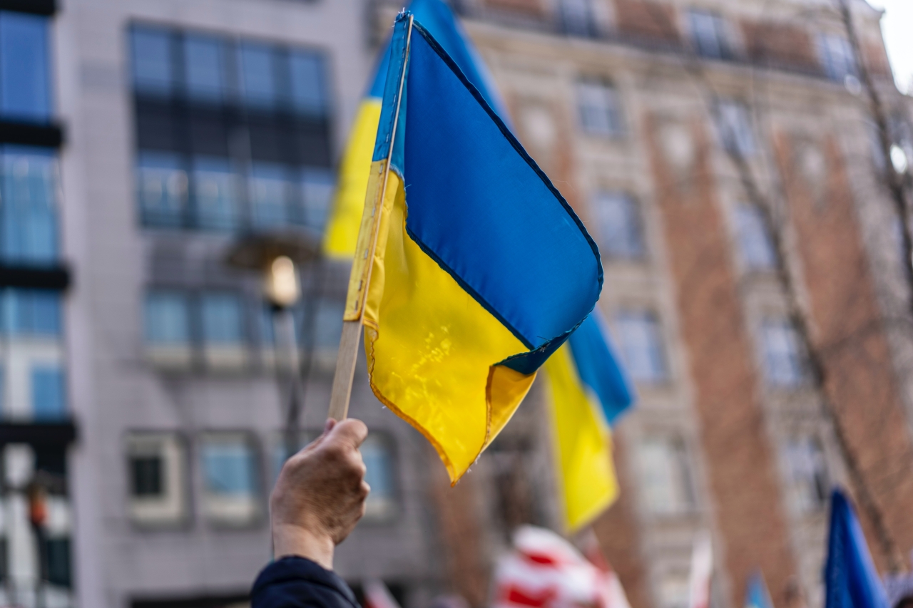 Hand waving a Ukrainian flag at a peace protest.
