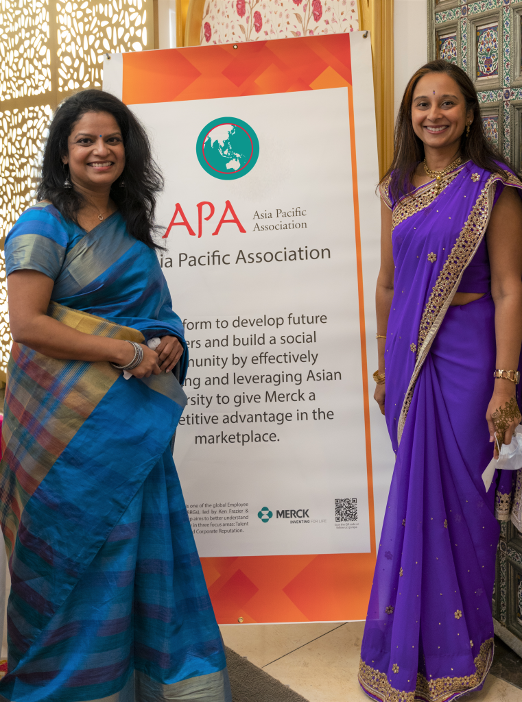 Two women next to Asia Pacific Association sign 
