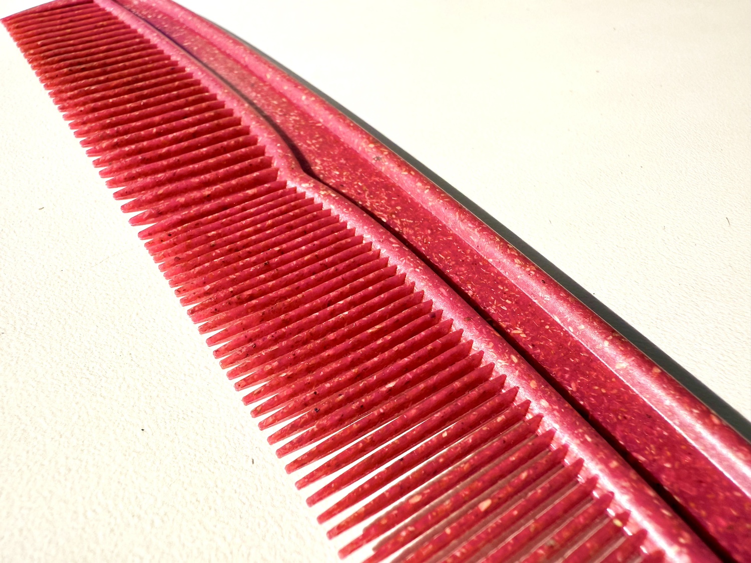 A rendering of a red plastic comb created with bamboo waste — Applied Bioplastics