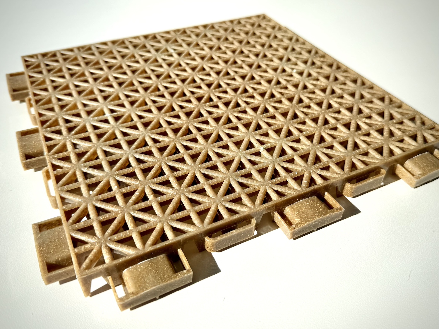 A rendering of a brown plastic floor panel used for athletic flooring — Applied Bioplastics