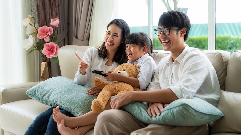 Asian American family seated on a couch.