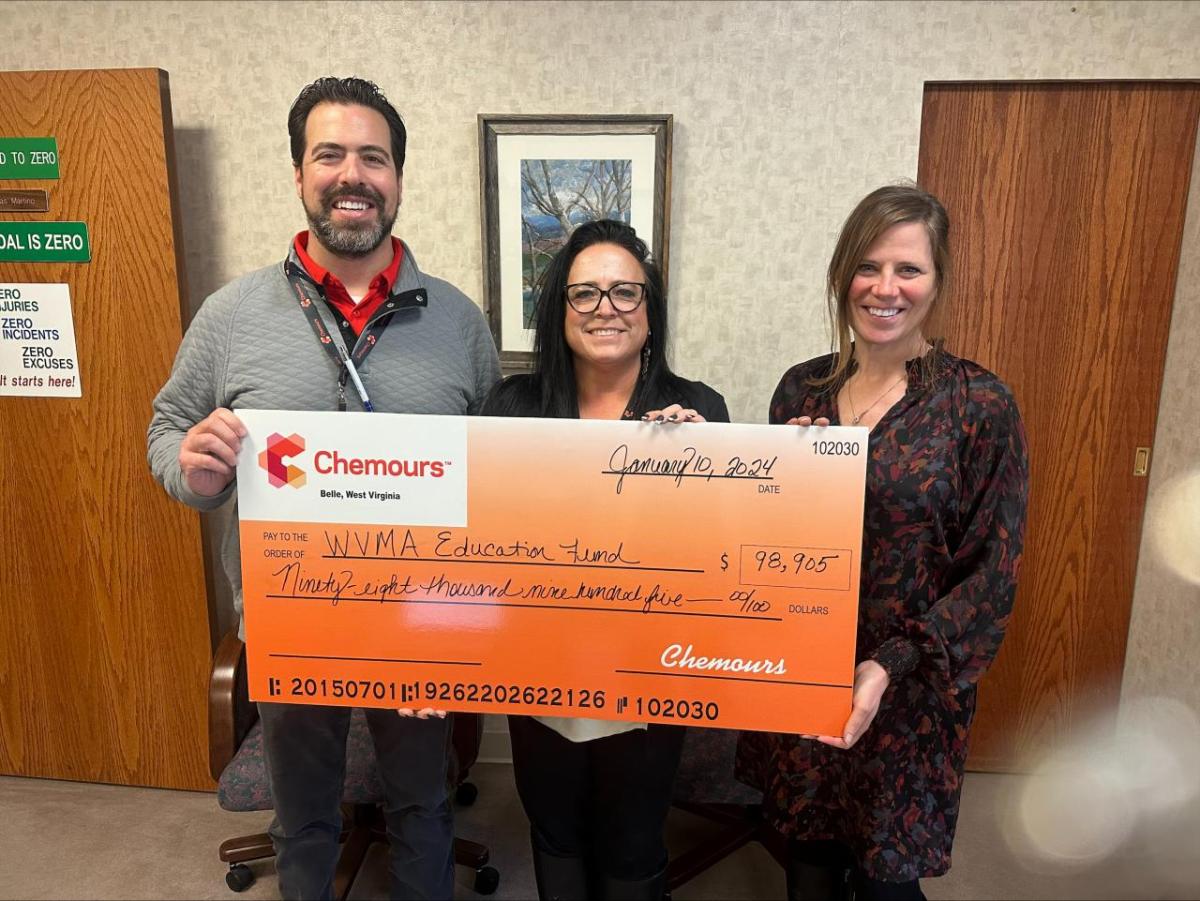 People standing together holding a large check from Chemours