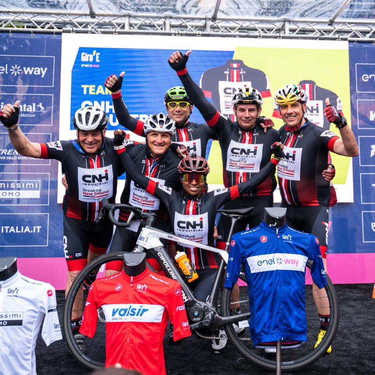 Bike riders in a group picture with thumbs up. 