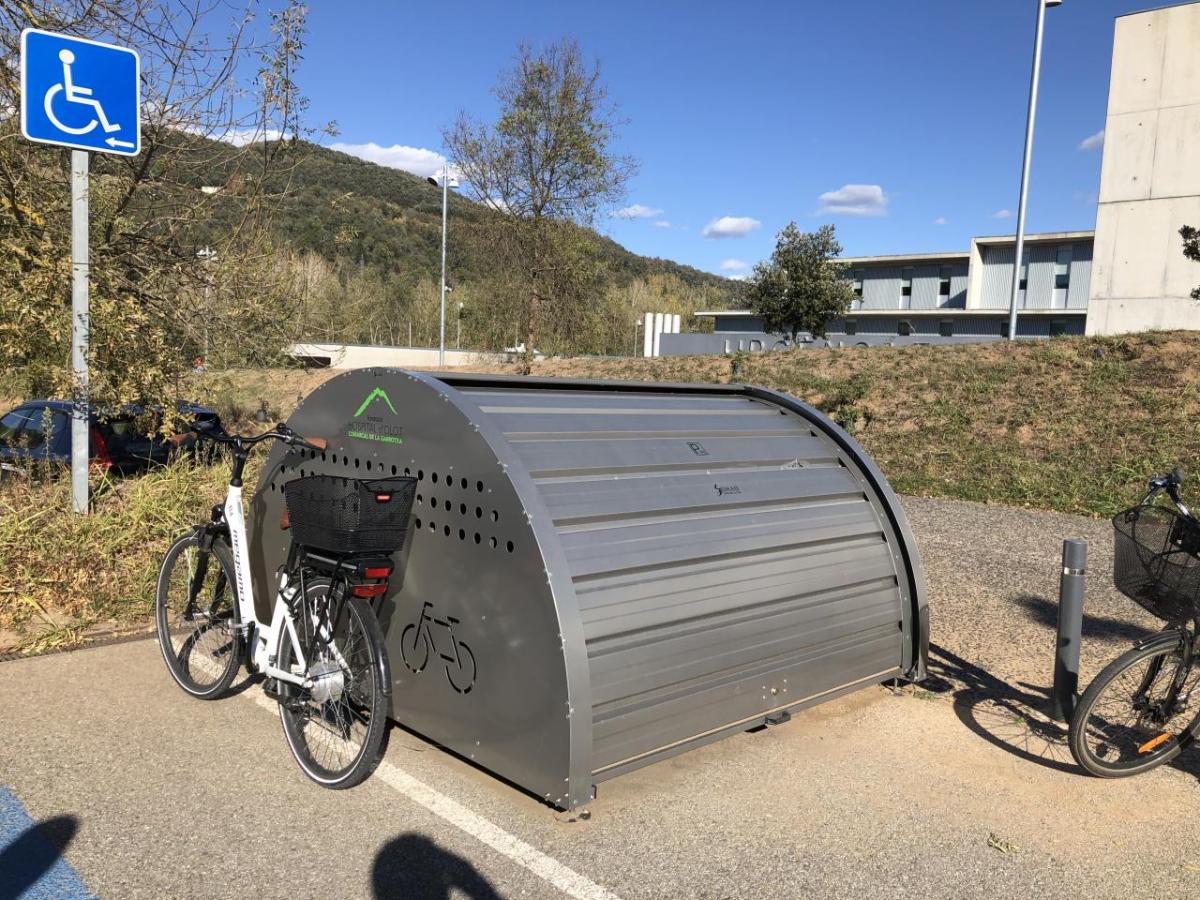 A bike storage container in a parking lot.