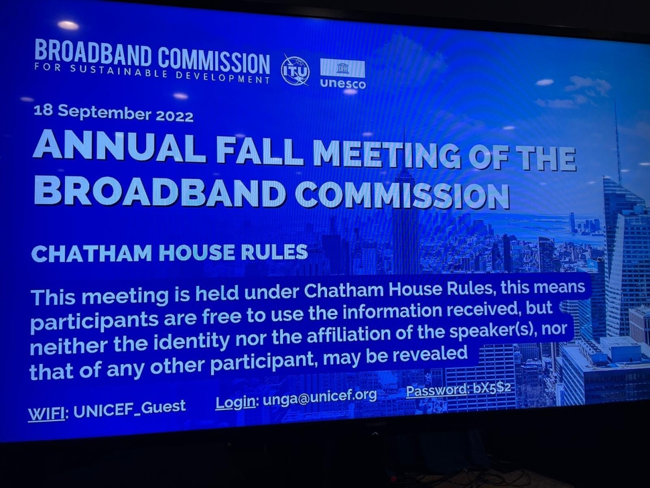 Presentation on a large screen "Annual fall meeting of the broadband commission" Chatham house rules.