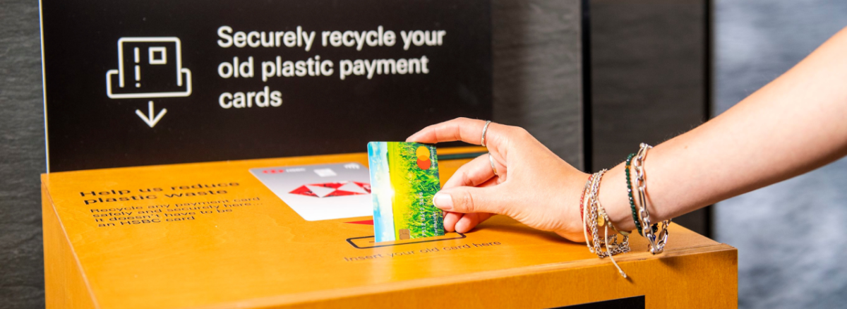 A person depositing a credit card into a recycling machine
