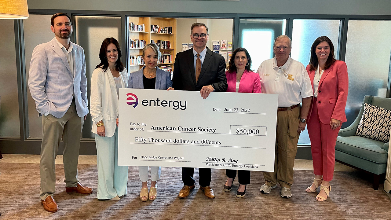 Seven people stand behind a large check from Entergy to the American Cancer Society for $50,000
