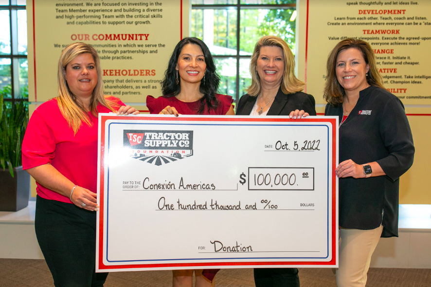 four people holding an oversized check