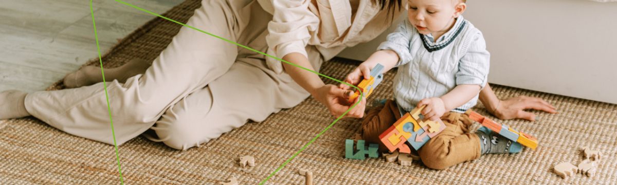 An adult and young child playing on the floor with colorful blocks.