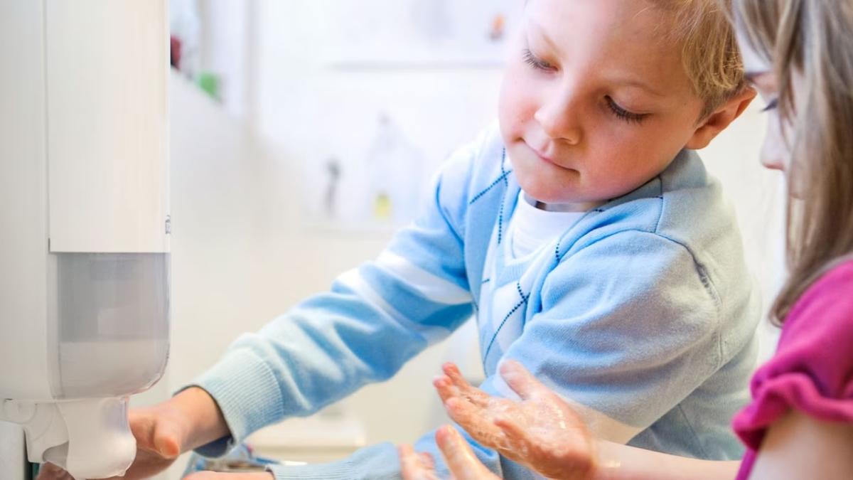 Two young children shown washing their hands.
