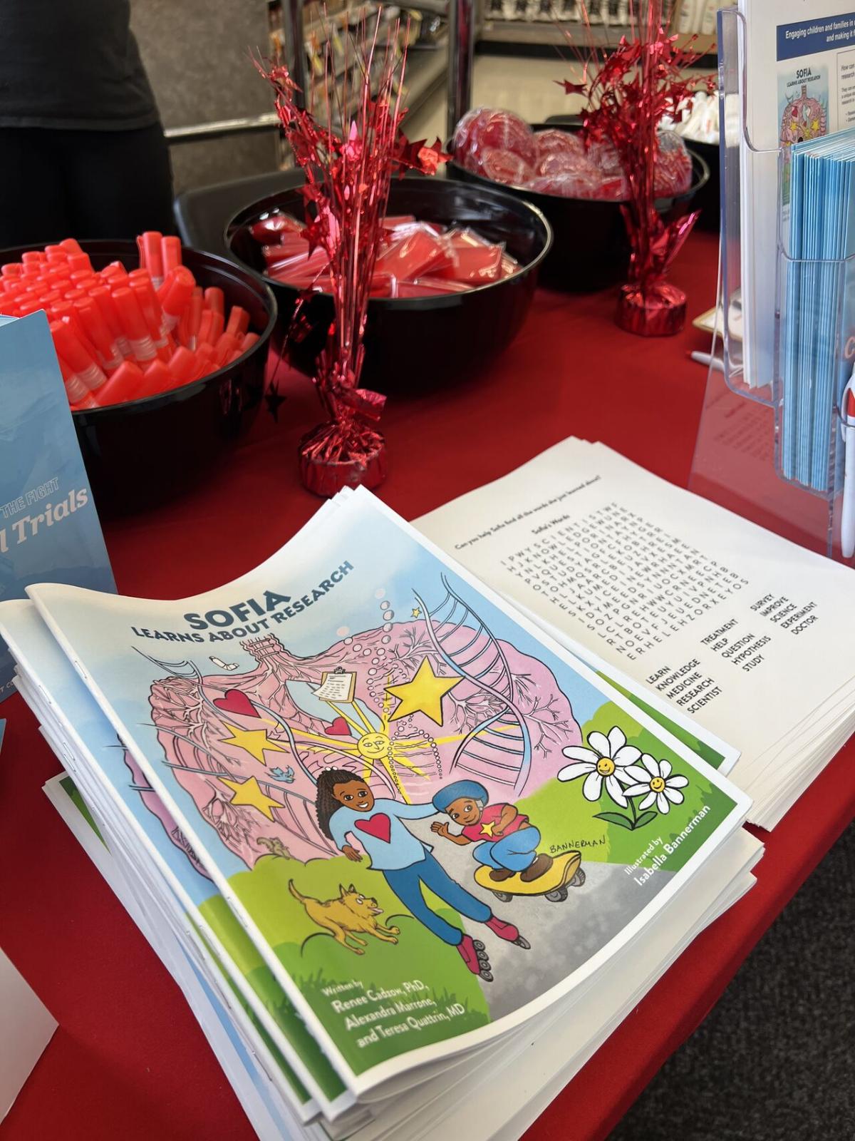 A children's book on a decorated table with treats and pamphlets.