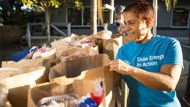 Person in a Duke Energy t-shirt handling grocery bags