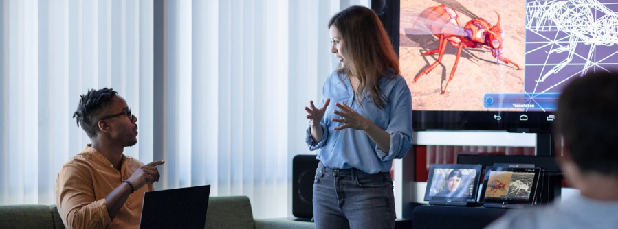 Employees talking in front of computers