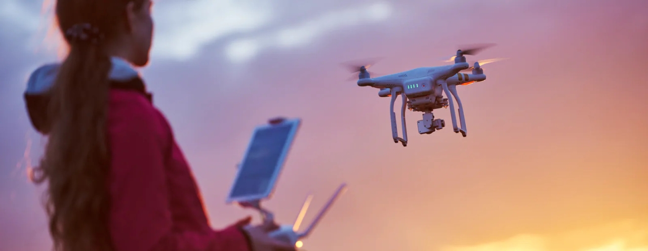 Person flying drone at sunset