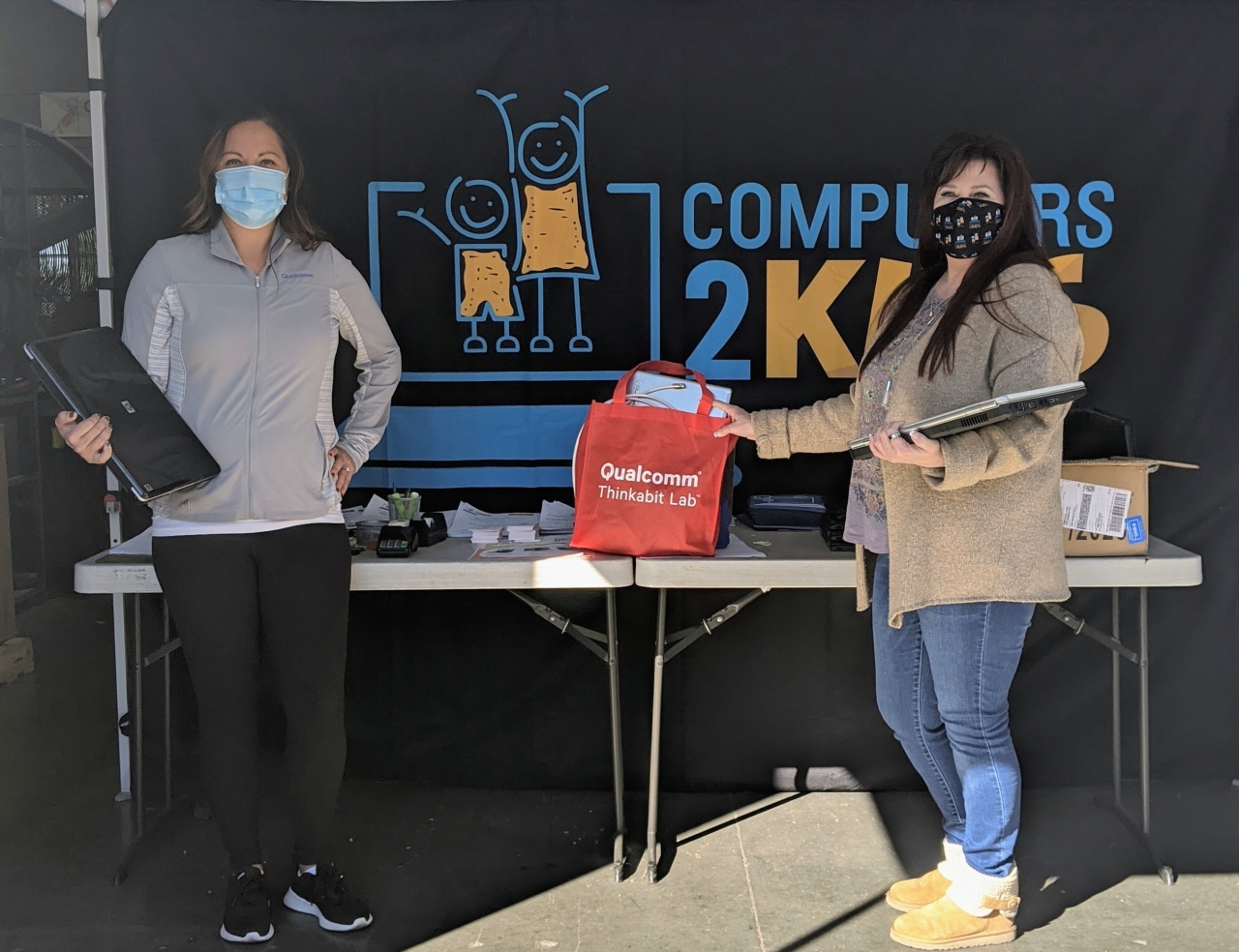 Natalie Dusi (L), Manager of Government Affairs, drops off a tech device donation to Cheri Pierre(R), CEO of Computers 2 Kids, as part of the drive which kicked off on National STEM Day 2020.