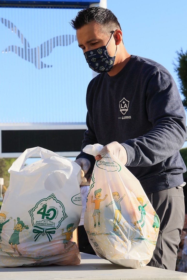 LA Galaxy volunteer distributes groceries to 350 vulnerable students during LA Harbor College's Spring Food Distribution event