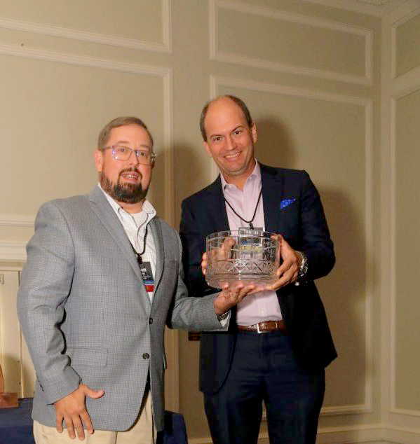 2 people holding an award