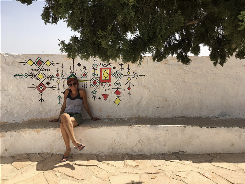 Rita Butman sitting against a wall