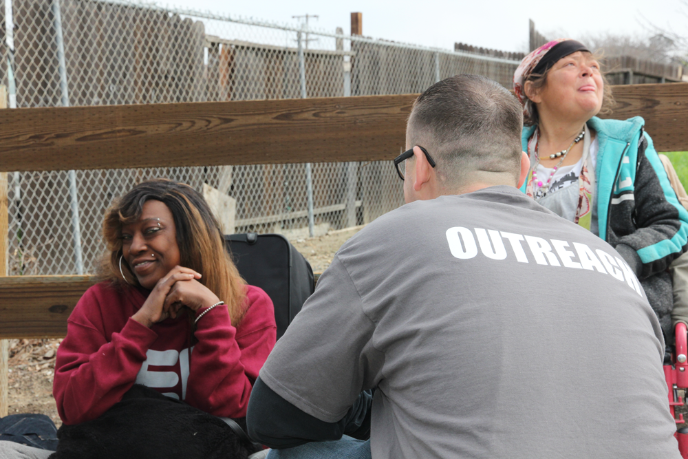 Outreach person helping two homeless people