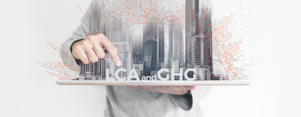 abstract of person holding a city on a board pointing to words "lca or ghg"