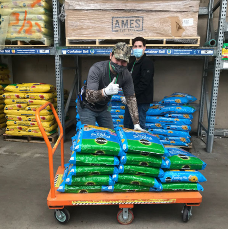 employee giving thumbs up after loading soil onto a cart