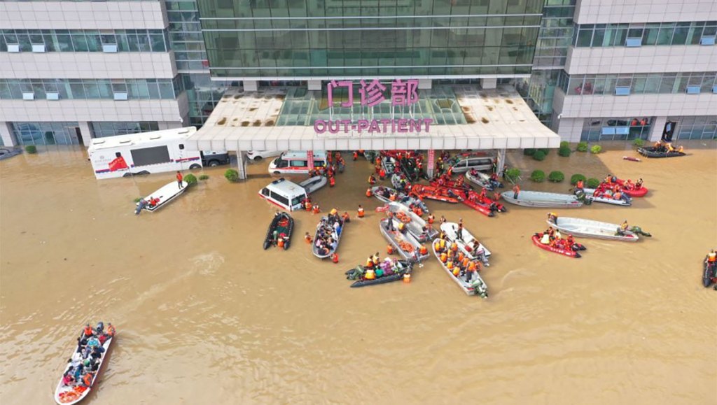 Image shows flooded hospital with many life boats escorting people to safety