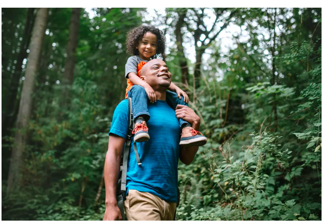 Child riding on fathers shoulders