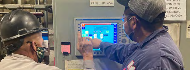 2 employees use a touch screen