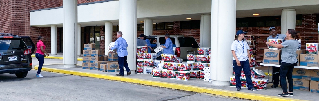 volunteers load toilet paper into cars