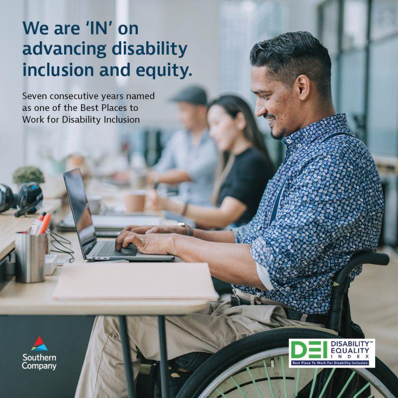 A person in a wheelchair at a desk working on a laptop. "We ar IN on advancing disability inclusion and equity."