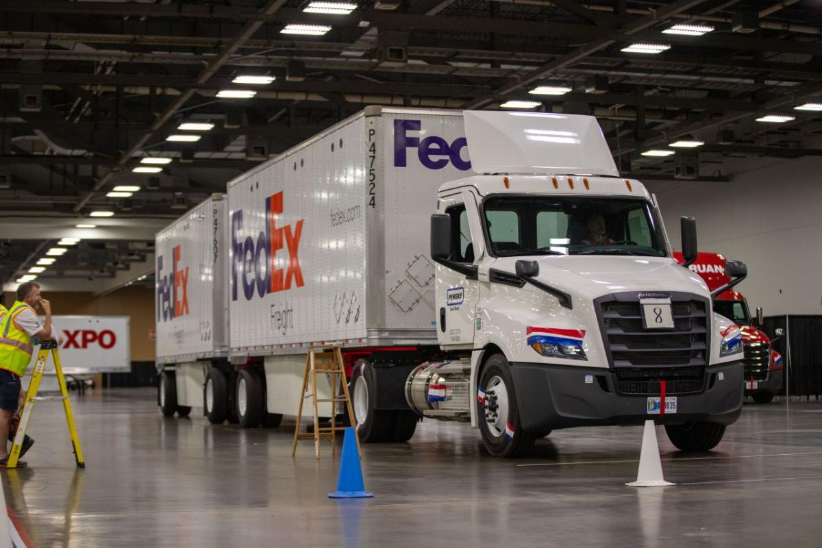 a large FedEx truck parked behind cones in a driving facility