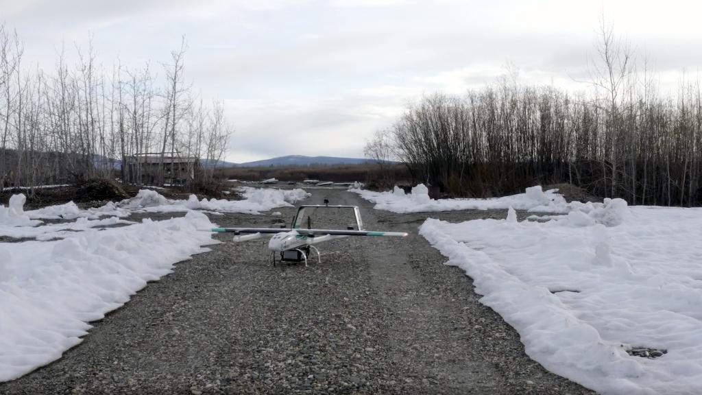 A drone on a cleared path with snow surrounding.