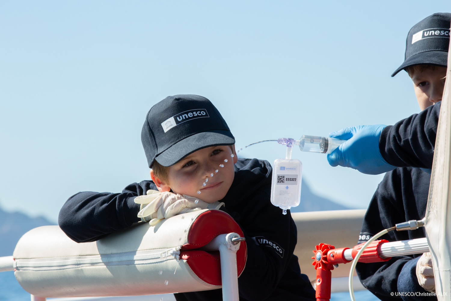 Young students help collect eDNA samples while on a boat in Corsica France. 