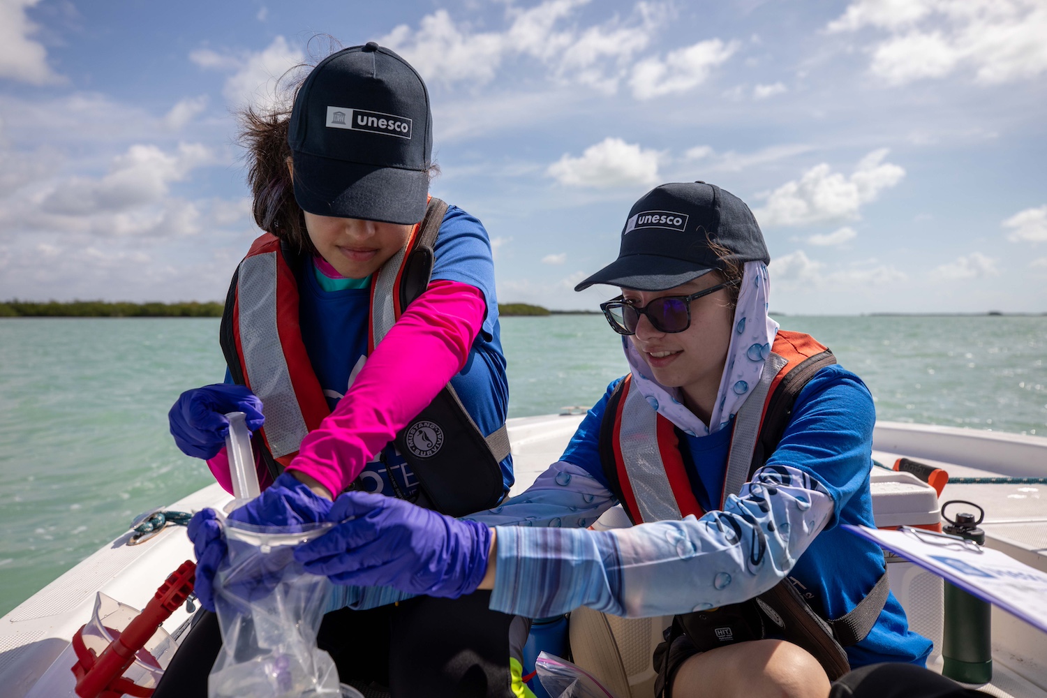 High school students on a boat collect eDNA samples in Florida's Everglades National Park.