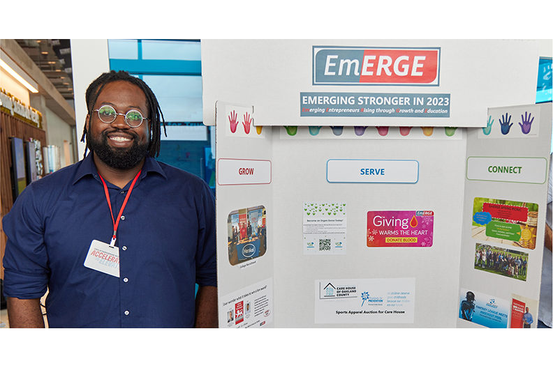 Henkel employee with an EmERGE poster