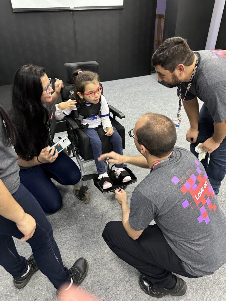 A child in a wheelchair with lenovo employees talking to them