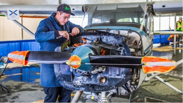 person working on small airplane