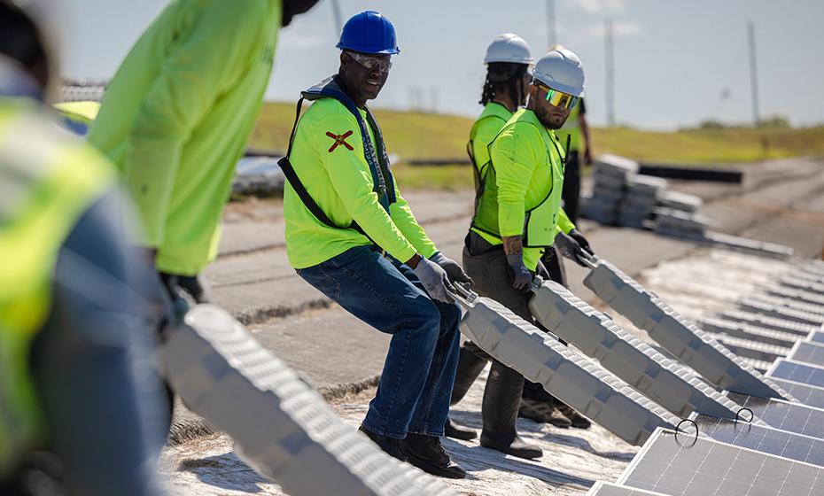 Group of working stood in a line constructing the floating solar array