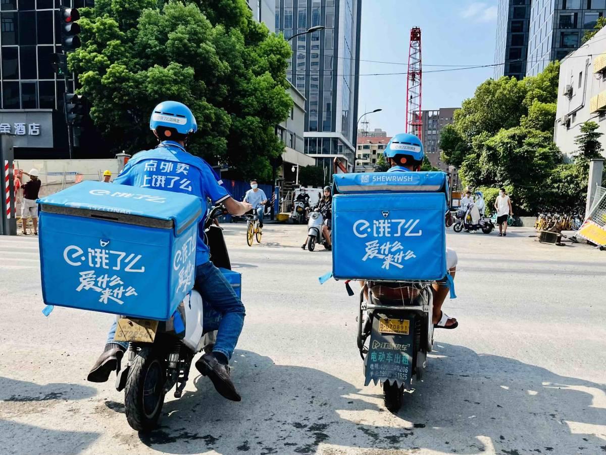 Two matching people on motorbikes, blue containers on the back.