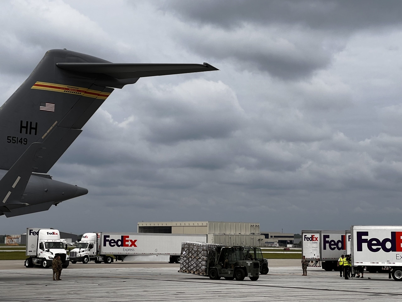 Military plane and Fedex trucks