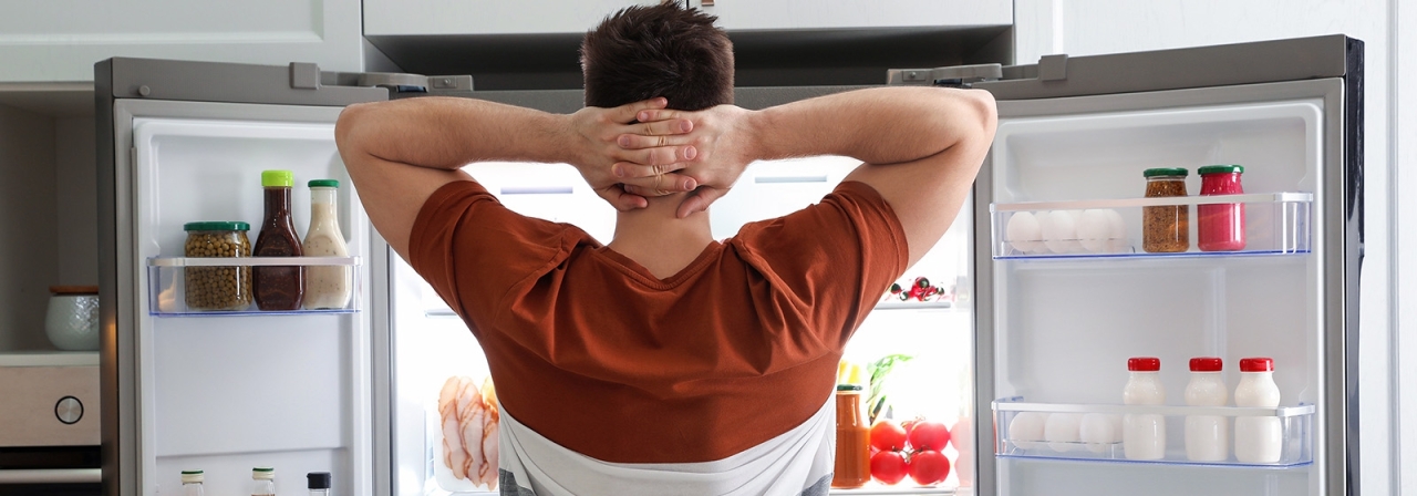 person standing in front of an open refrigerator