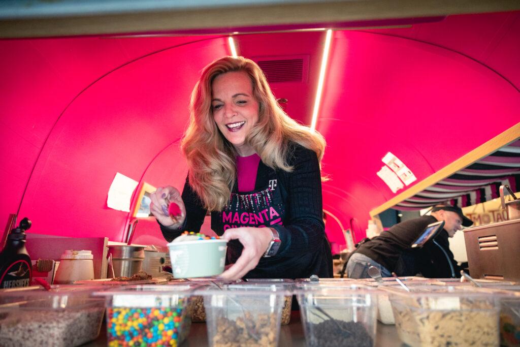 A person putting toppings on a cup of froyo in a pick trailer.