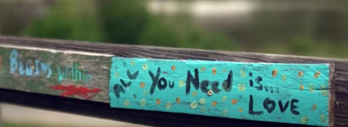 board painted with the words "all you need is love"