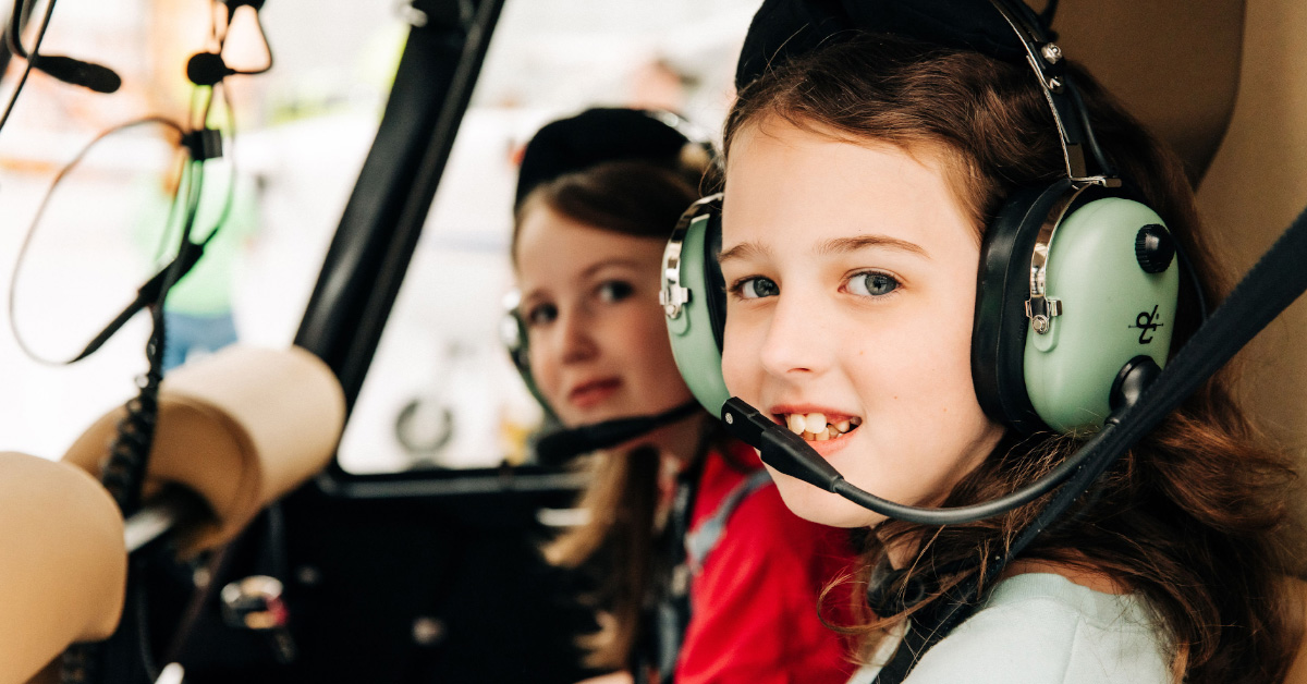 two children sitting in a plane wearing headphones