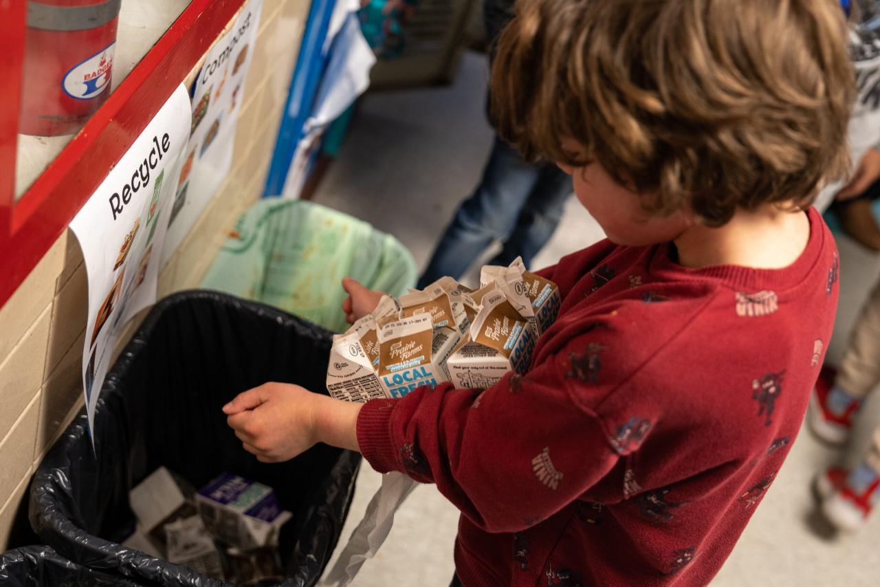 child recycling a carton