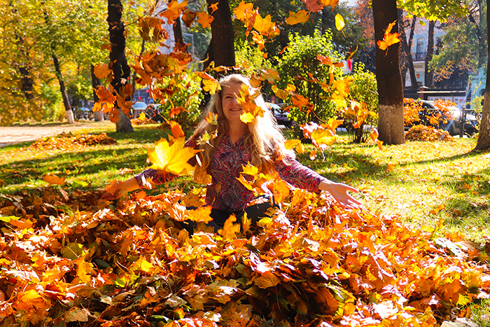 person playing in a pile of leaves