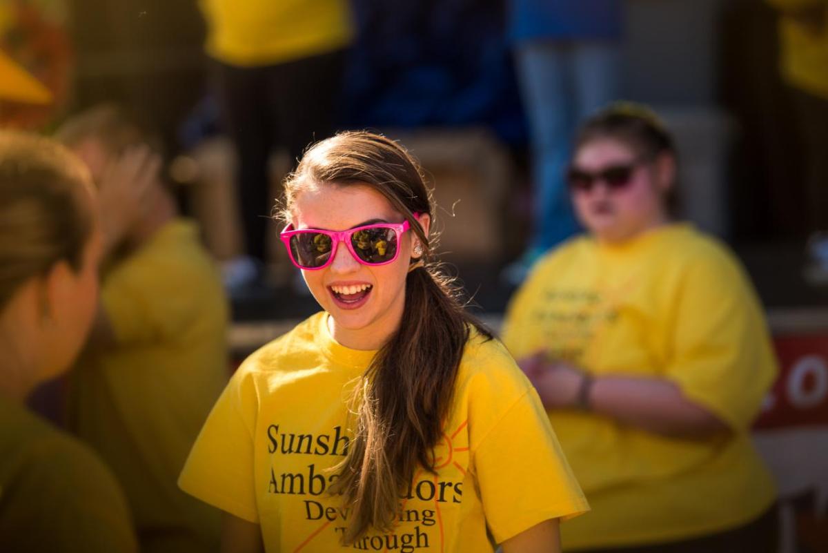 person smiling in a yellow tshirt