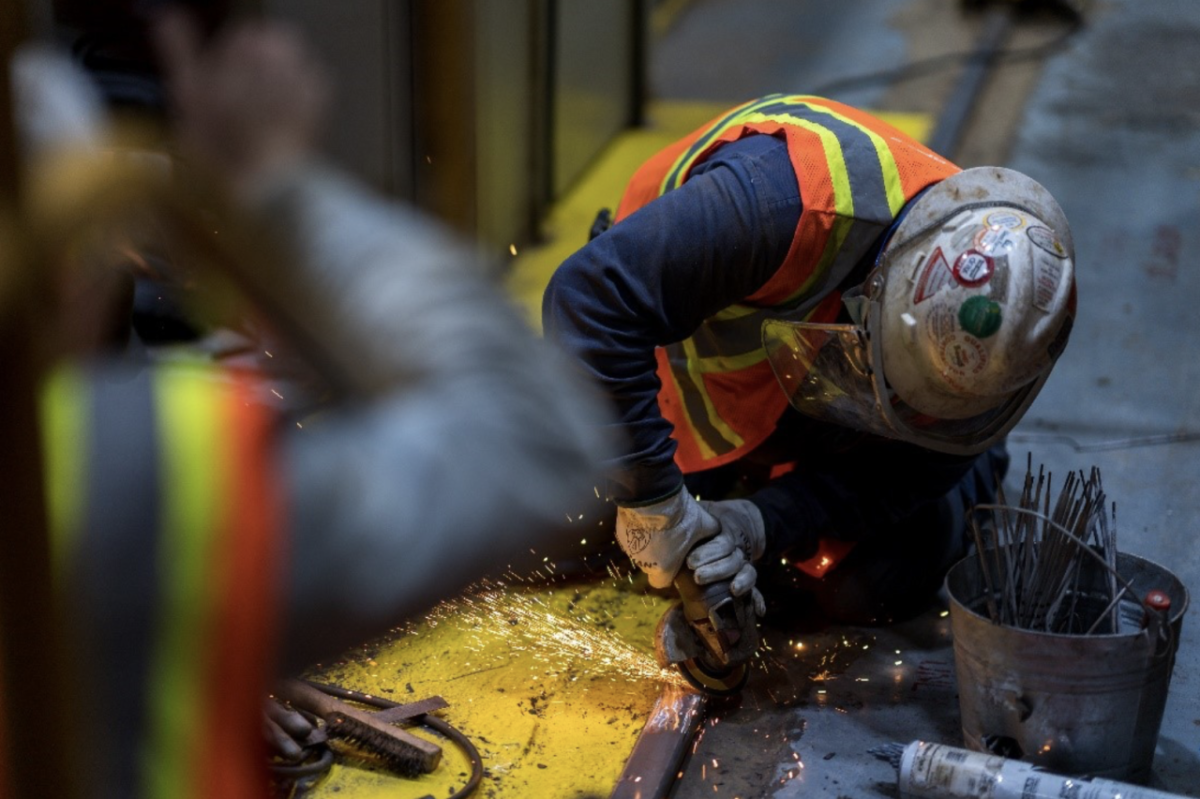 worker in safety gear using an angle grinder